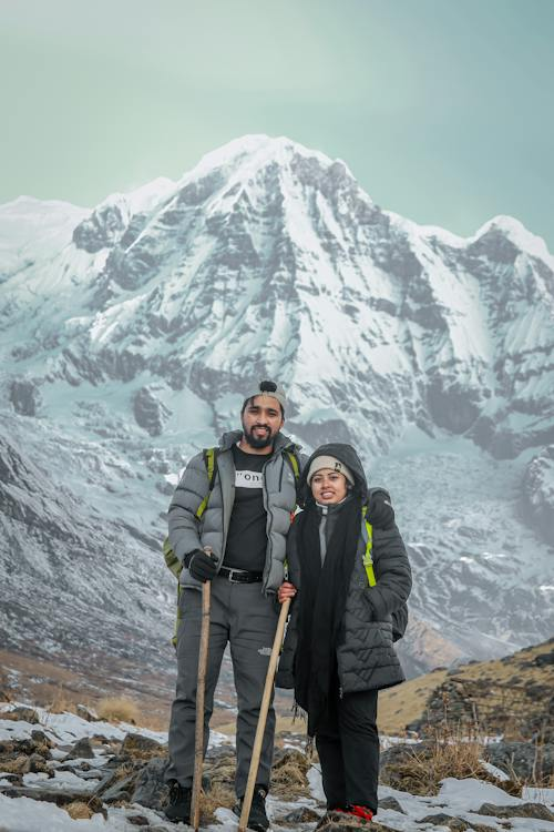 a couple standing in front of a mountain