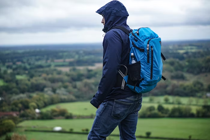 A photo of a hiker standing on top of an elevated surface.