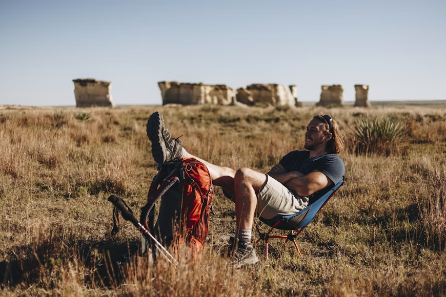  A photo of a person sitting on a foldable chair.