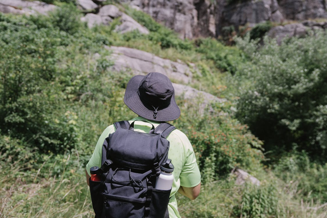Hiker wearing a backpack on a rocky trail.