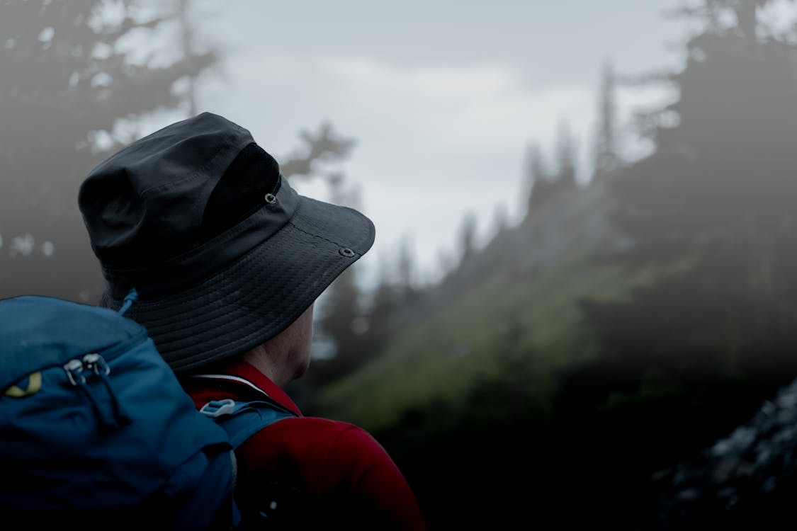 Hiker wearing a backpack in misty mountains.